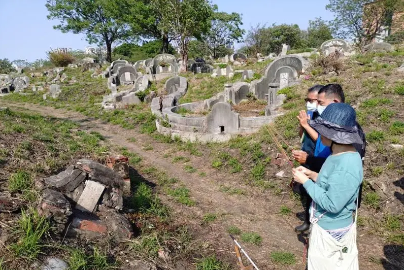 A man honors a lost ancestor found through the Saving Nanshan Cemetery project.